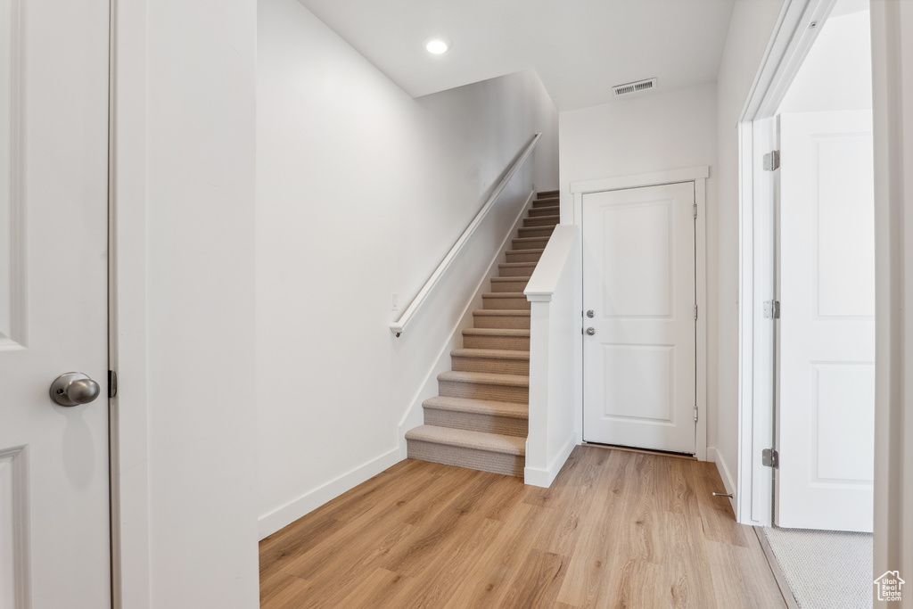 Stairway featuring wood finished floors, baseboards, and recessed lighting