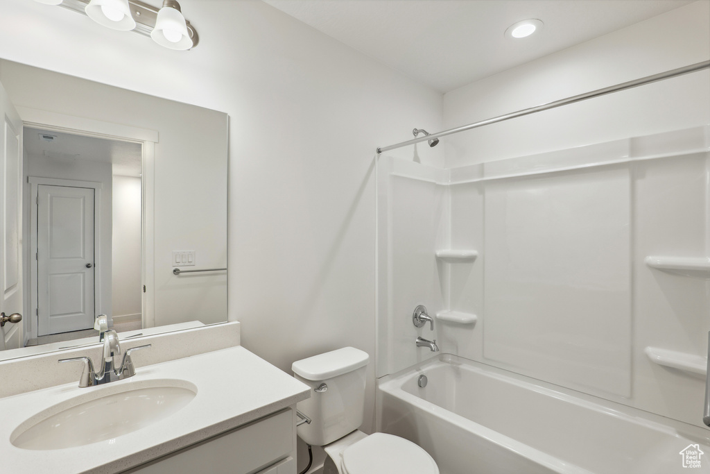 Bathroom featuring  shower combination, vanity, toilet, and recessed lighting
