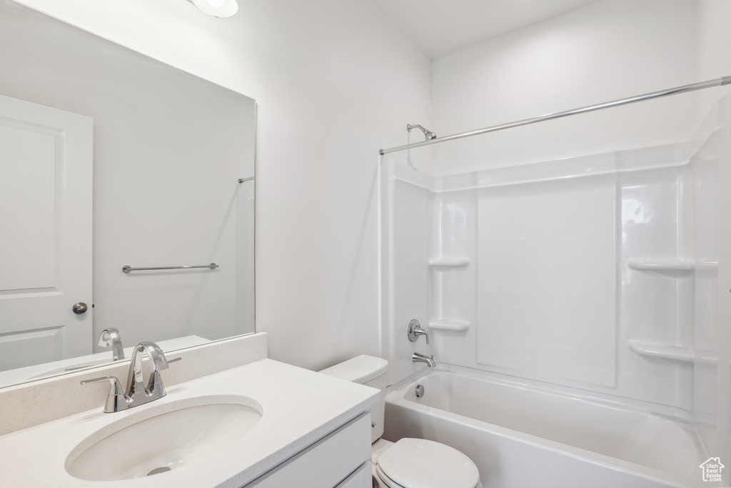Bathroom featuring vanity,  shower combination, and toilet