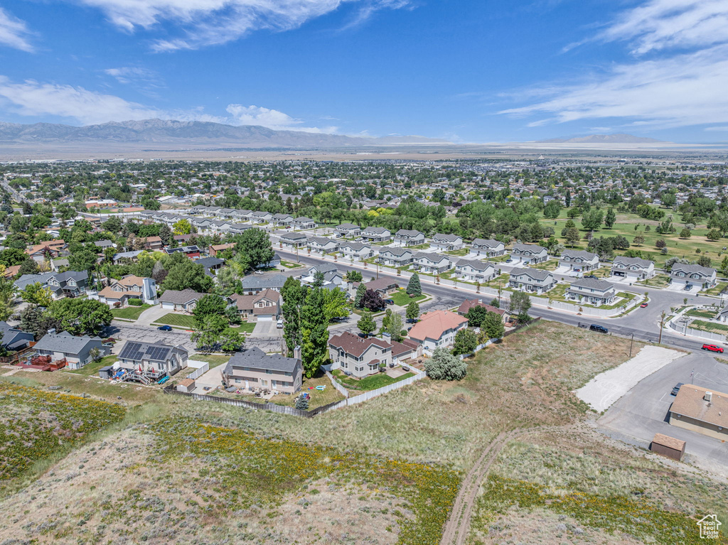 Aerial view of property and surrounding area with a mountain backdrop and nearby suburban area