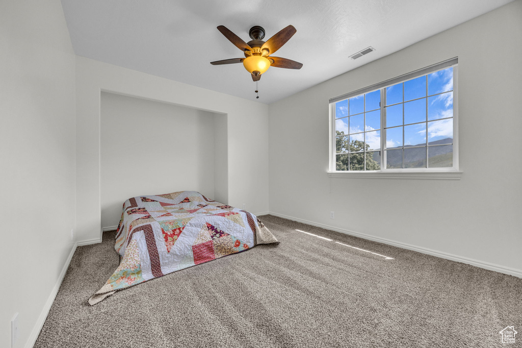 Bedroom with carpet floors, baseboards, and ceiling fan