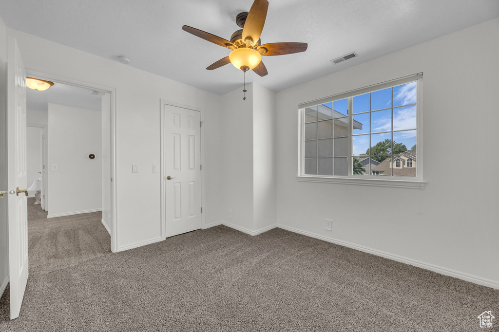 Unfurnished bedroom featuring carpet, baseboards, and ceiling fan