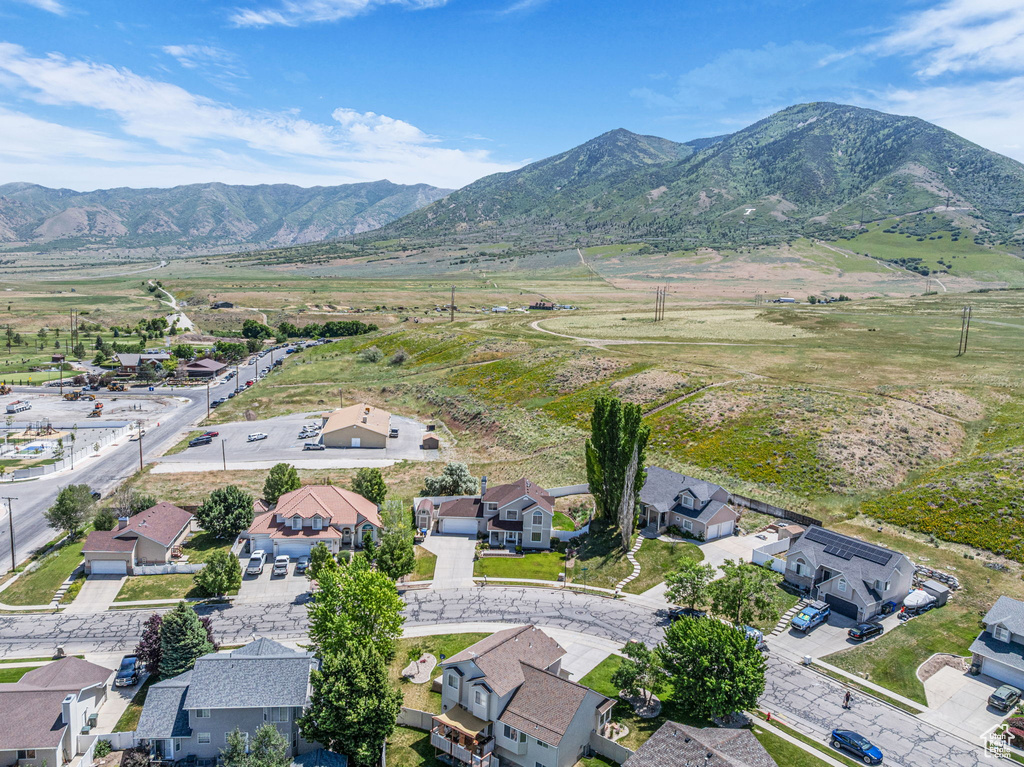 Aerial view of property and surrounding area featuring a mountain backdrop and nearby suburban area
