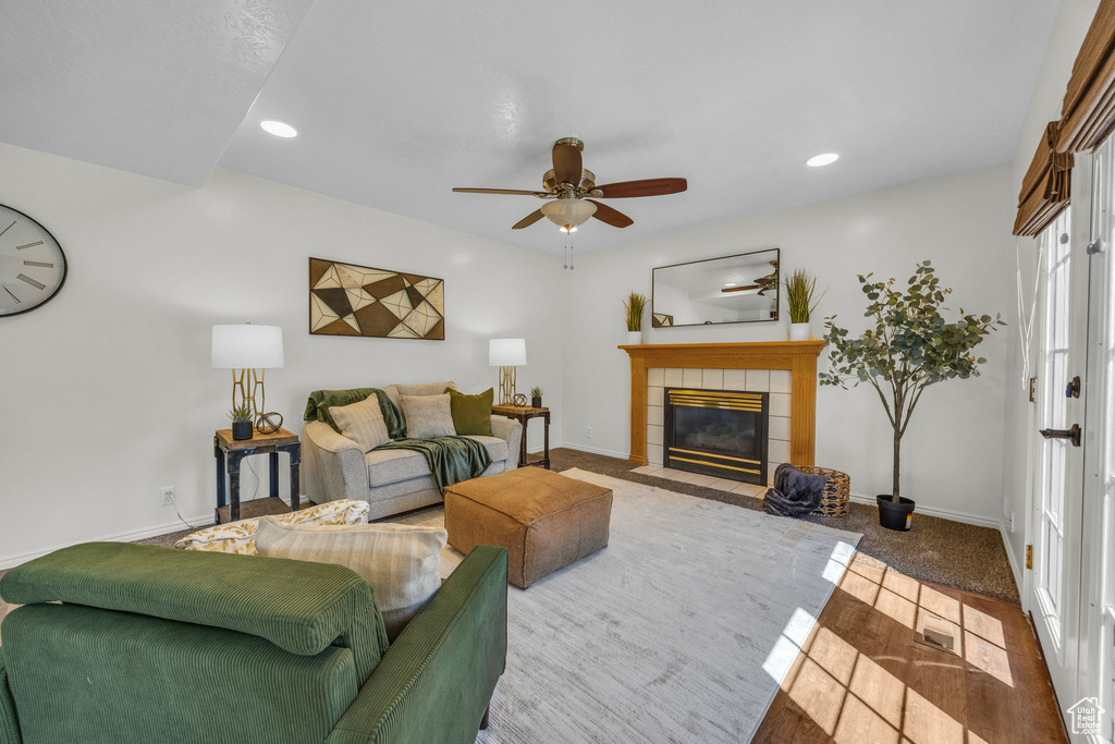 Living room featuring a ceiling fan, a tile fireplace, baseboards, and recessed lighting