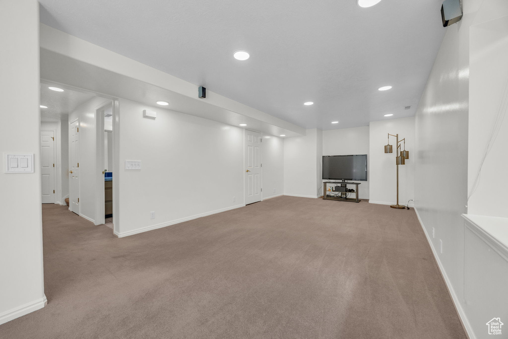 Unfurnished living room with carpet floors, recessed lighting, and baseboards