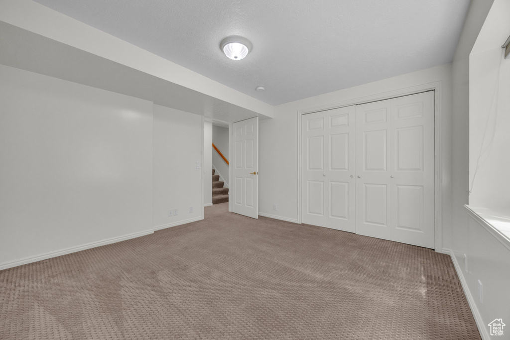 Unfurnished bedroom with baseboards, carpet, and a closet