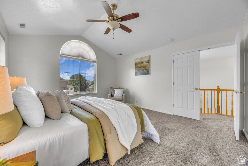 Carpeted bedroom featuring lofted ceiling, ceiling fan, and baseboards