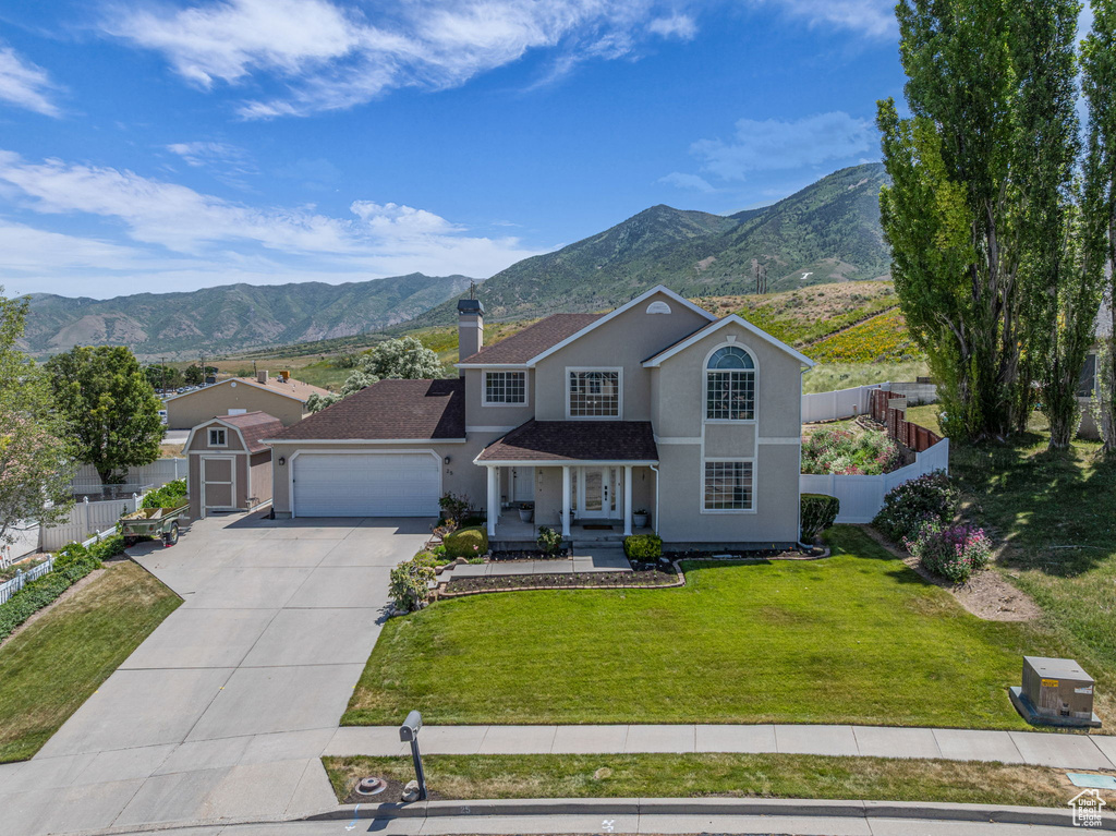 Traditional-style home featuring stucco siding, a mountain view, driveway, and a chimney