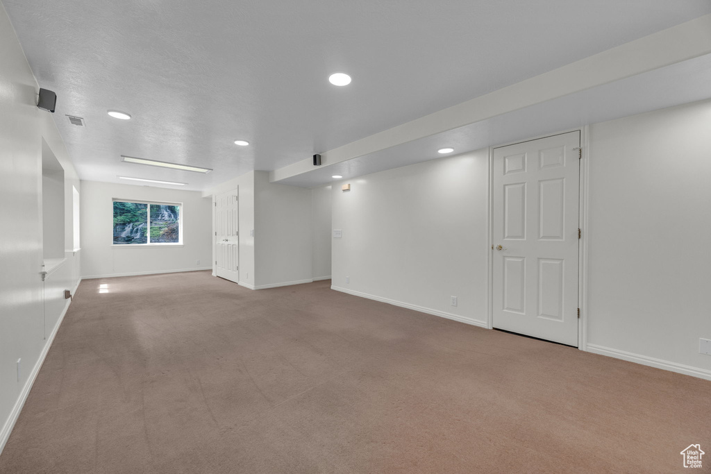 Carpeted spare room with baseboards and recessed lighting