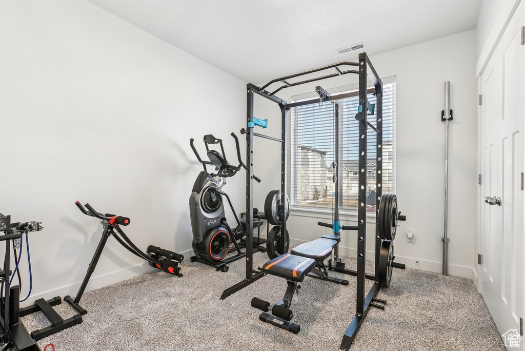 Exercise room with baseboards and carpet