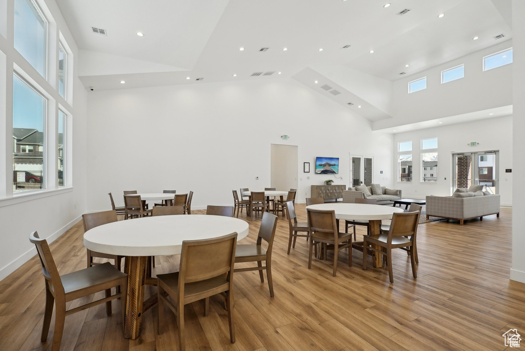 Dining room featuring high vaulted ceiling, light wood-style flooring, plenty of natural light, and recessed lighting