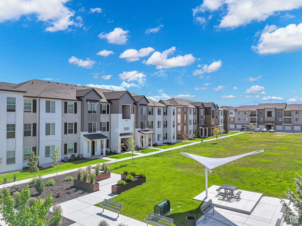 View of property's community with a residential view, a yard, and a patio area