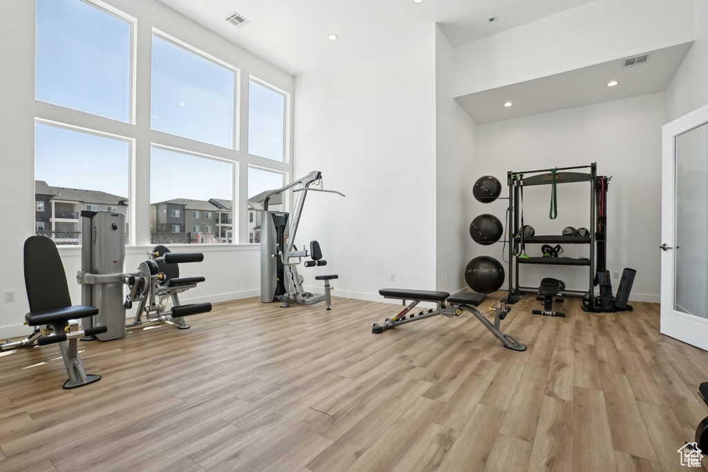 Exercise room featuring wood finished floors, recessed lighting, and baseboards