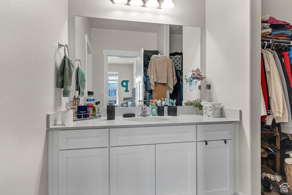 Bathroom with vanity and a walk in closet