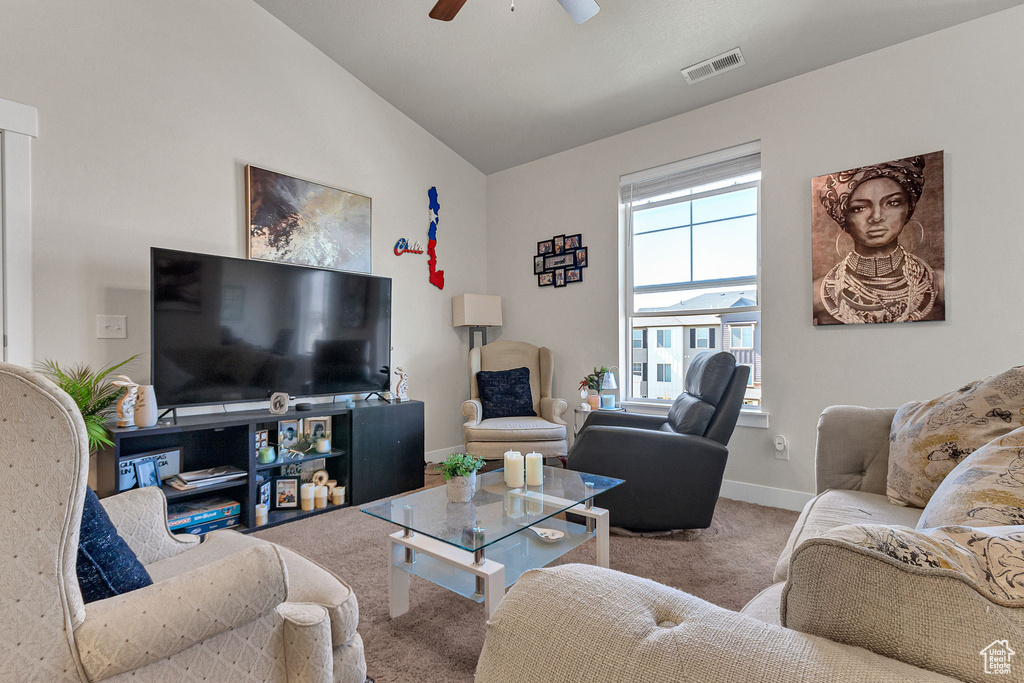 Living room with carpet flooring, a ceiling fan, vaulted ceiling, and baseboards