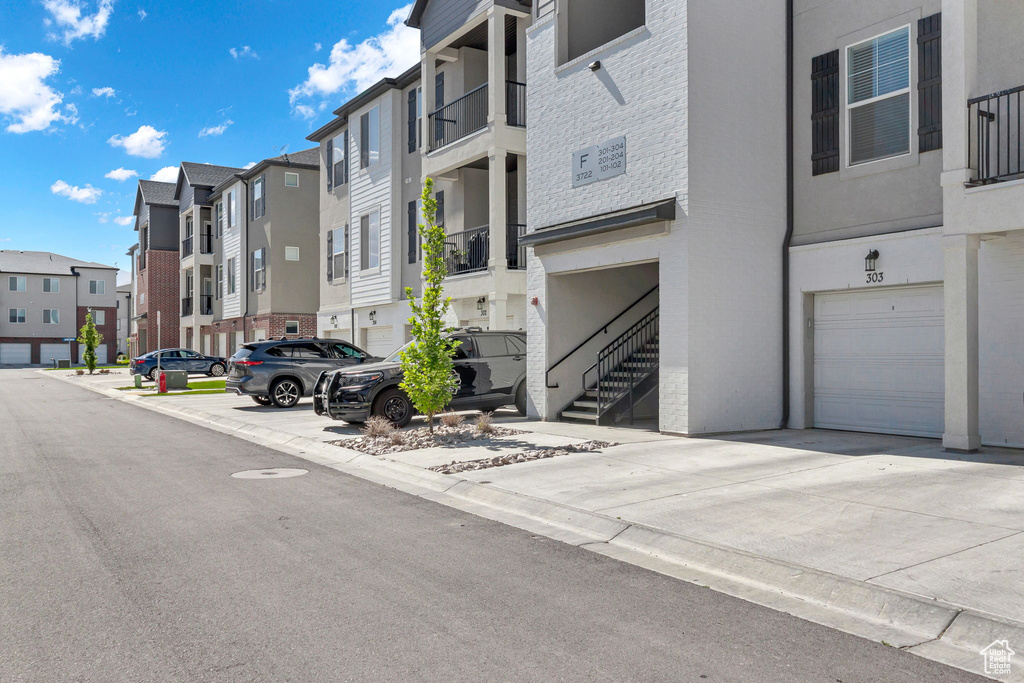 View of building exterior with an attached garage and a residential view