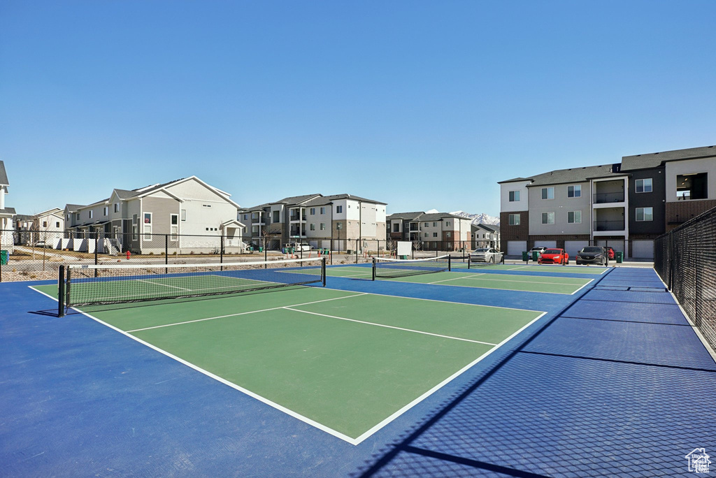 View of tennis court featuring a residential view