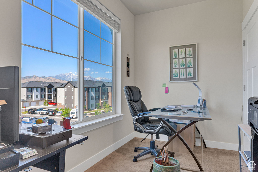 Carpeted office space with baseboards, a residential view, and a mountain view