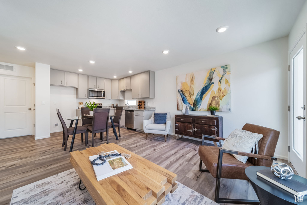 Living area featuring light wood-style flooring and recessed lighting