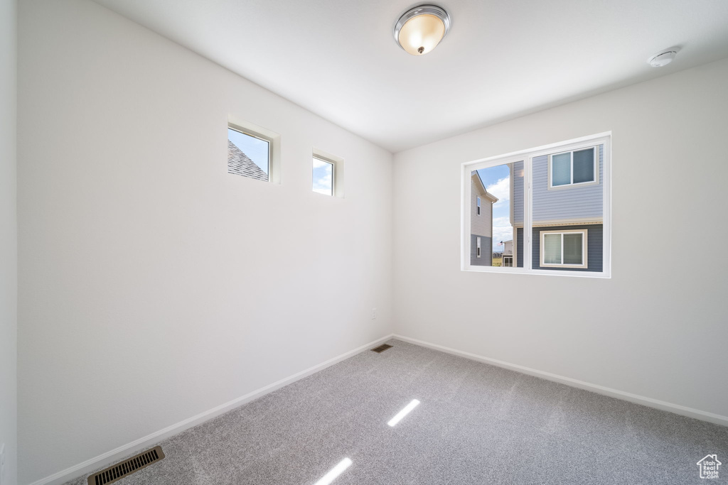 Unfurnished room featuring carpet flooring and a smoke detector