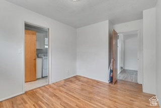Unfurnished room featuring washer and dryer and light wood-type flooring
