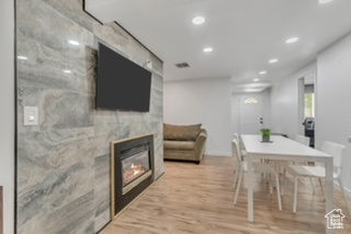 Dining space featuring recessed lighting, wood finished floors, and a fireplace