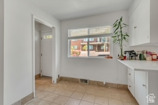 Unfurnished dining area featuring baseboards and light tile patterned floors