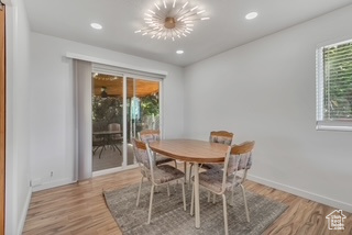 Dining room with light wood finished floors, baseboards, and recessed lighting