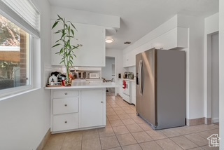 Kitchen with stainless steel fridge with ice dispenser, white cabinetry, plenty of natural light, and stove
