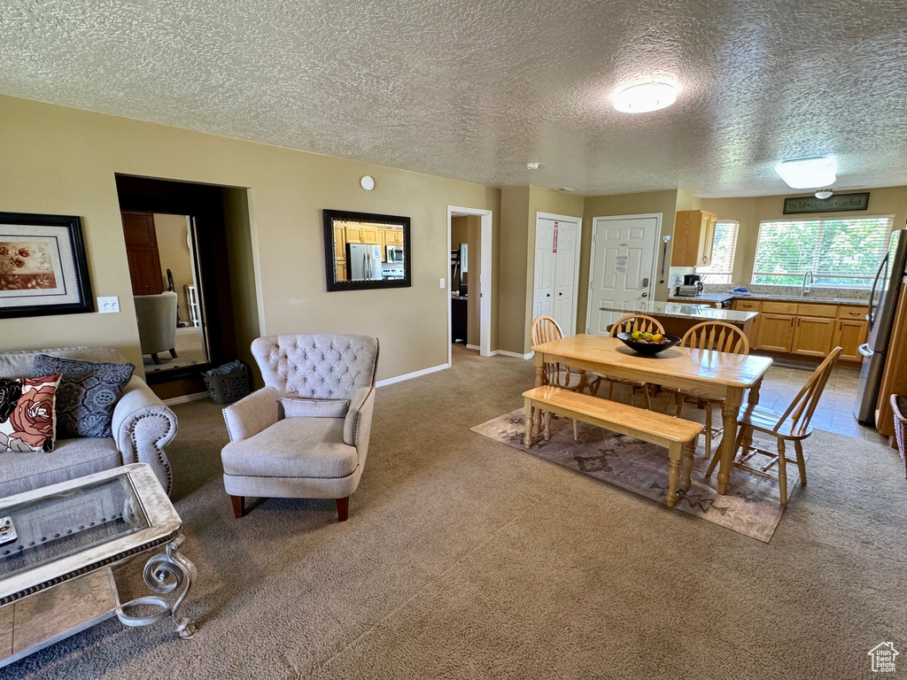 Dining space with carpet and a textured ceiling