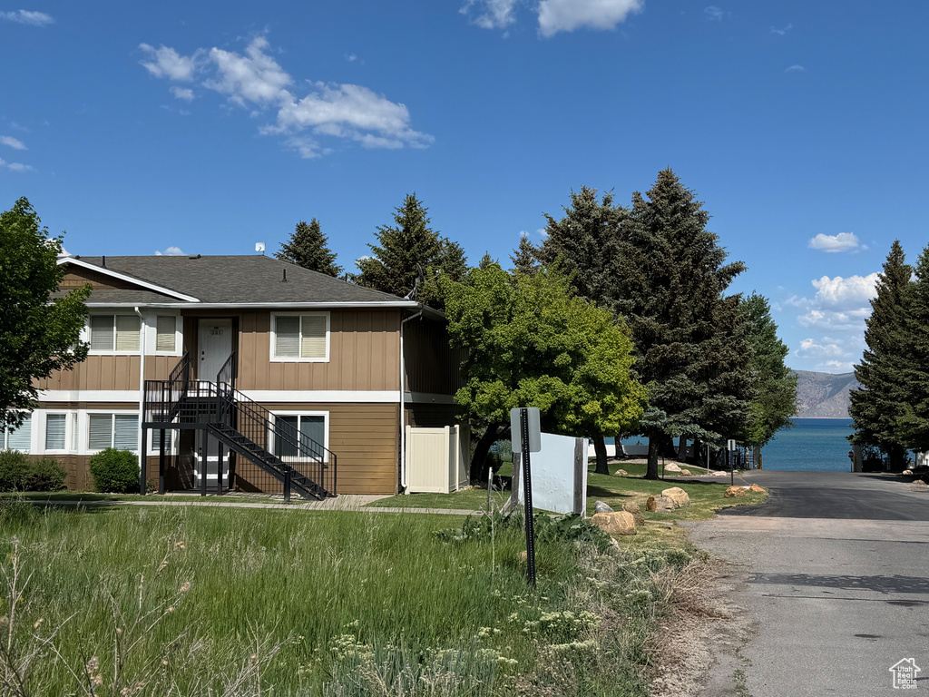 View of front of home featuring board and batten siding and roof with shingles