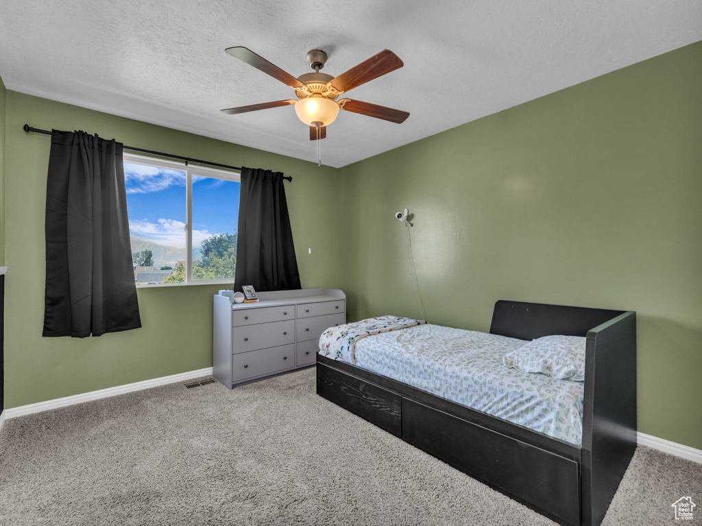 Bedroom featuring baseboards, carpet flooring, and a ceiling fan