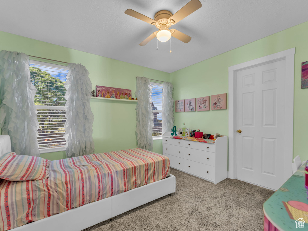 Carpeted bedroom featuring ceiling fan