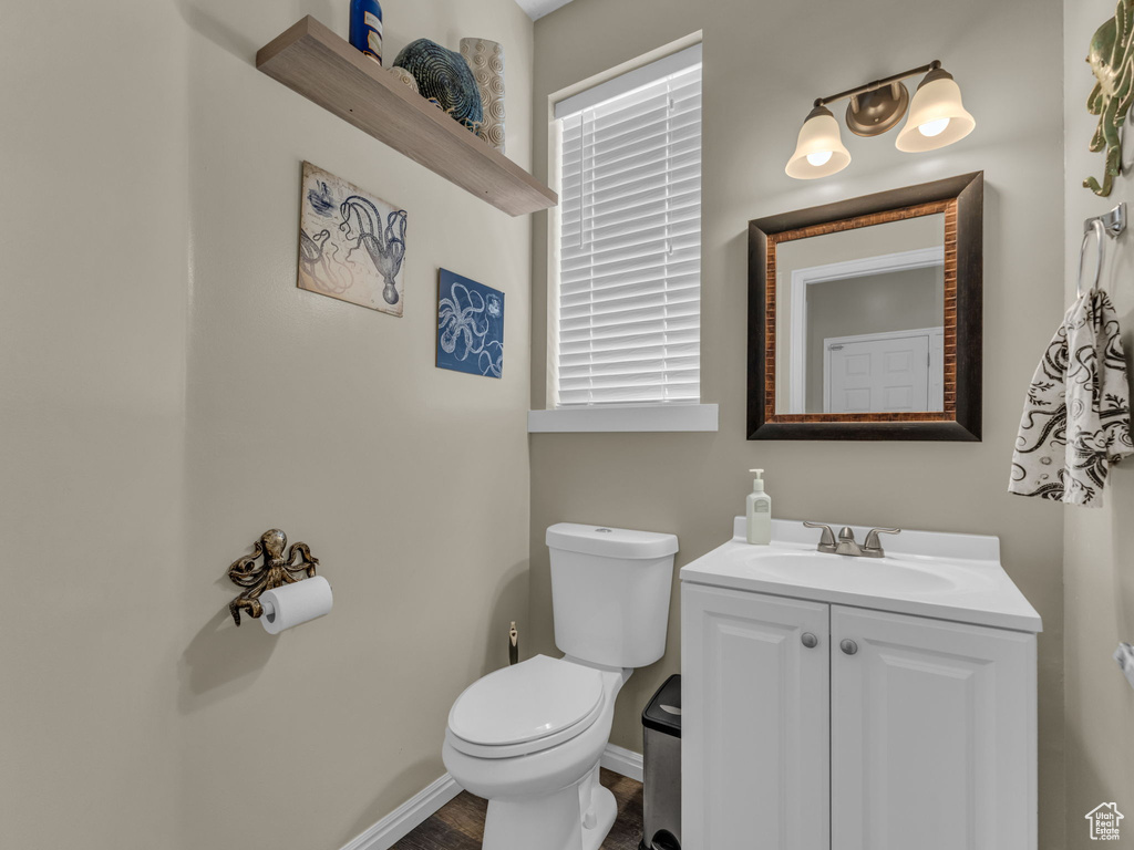 Bathroom featuring toilet, vanity, and baseboards