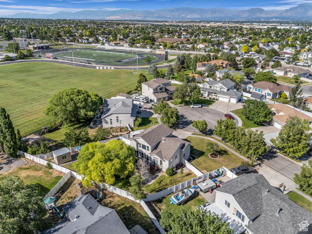 Aerial view of property and surrounding area with nearby suburban area and a mountain backdrop