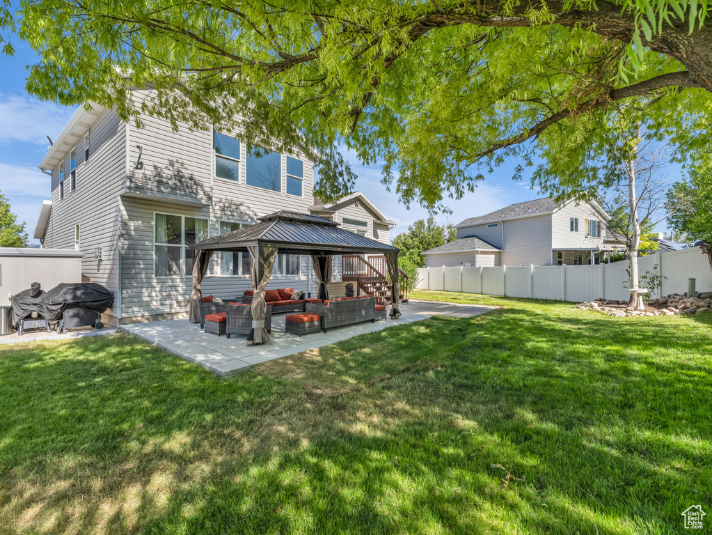 Back of property featuring a gazebo, a patio, and an outdoor living space