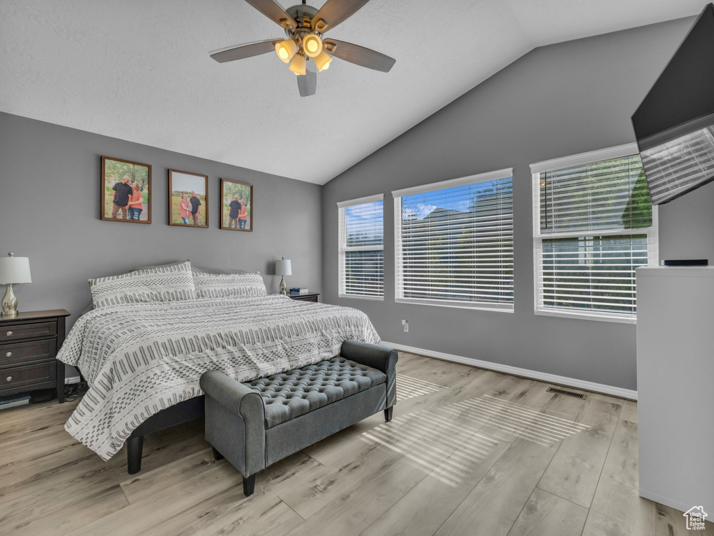 Bedroom featuring lofted ceiling, wood finished floors, baseboards, and ceiling fan