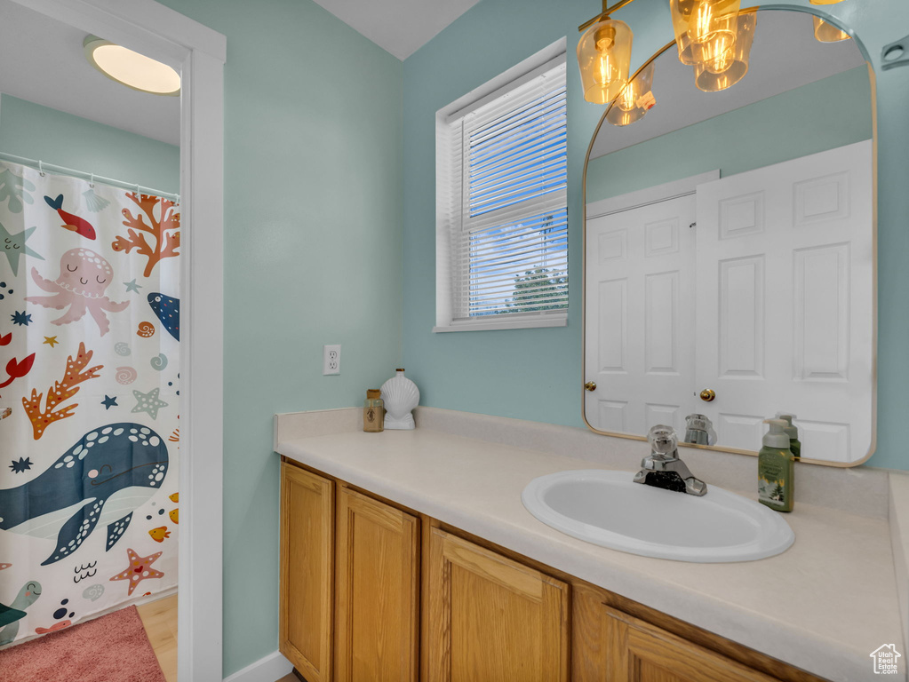 Full bathroom featuring vanity, a chandelier, and a shower with curtain
