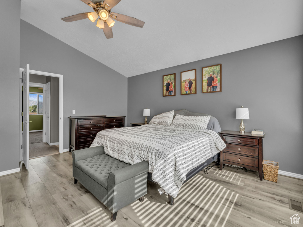 Bedroom featuring lofted ceiling, baseboards, wood finished floors, and a ceiling fan