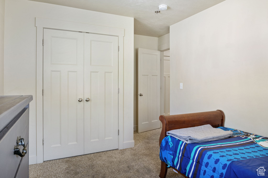 Bedroom featuring light carpet and a closet