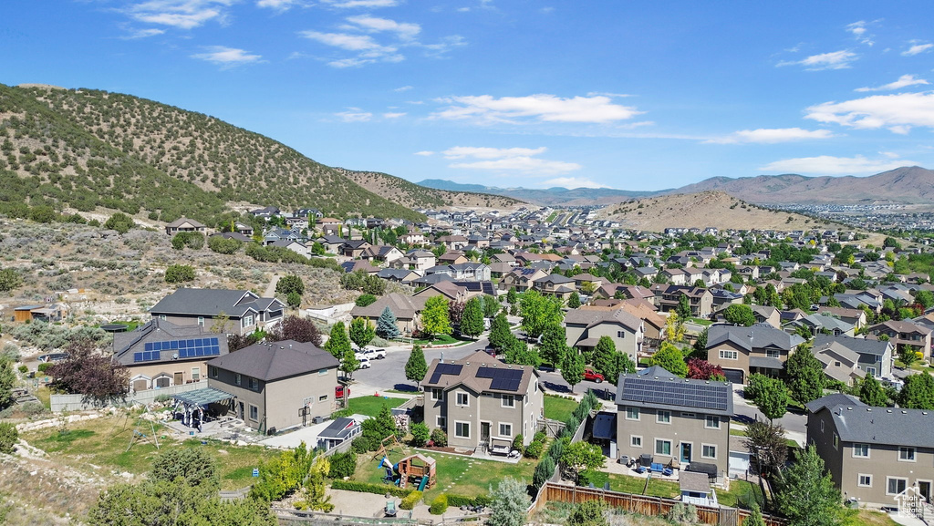 Aerial view of property and surrounding area featuring a mountain backdrop and nearby suburban area