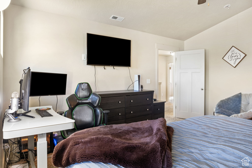 Bedroom with vaulted ceiling, an office area, and carpet