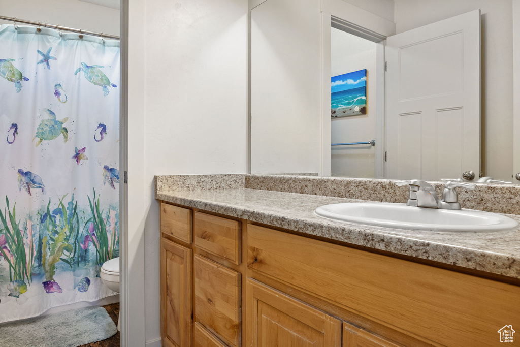 Full bath with vanity, toilet, and a shower with curtain