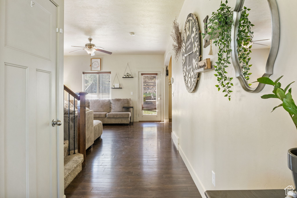 Hallway featuring dark wood finished floors and baseboards