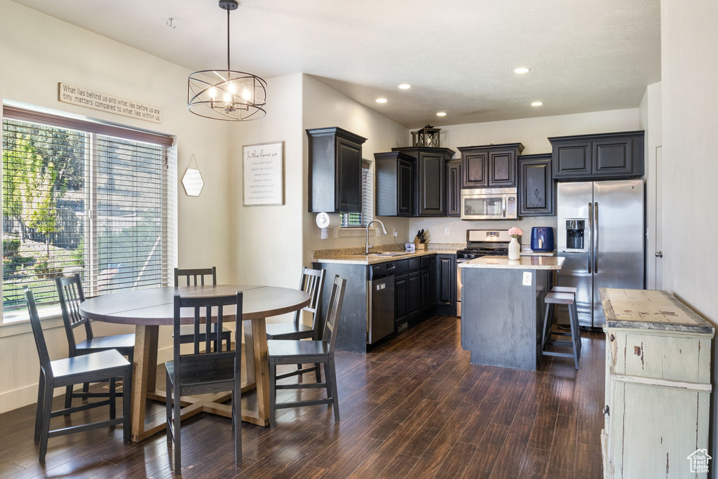 Kitchen featuring stainless steel appliances, a sink, light countertops, dark wood-style flooring, and recessed lighting