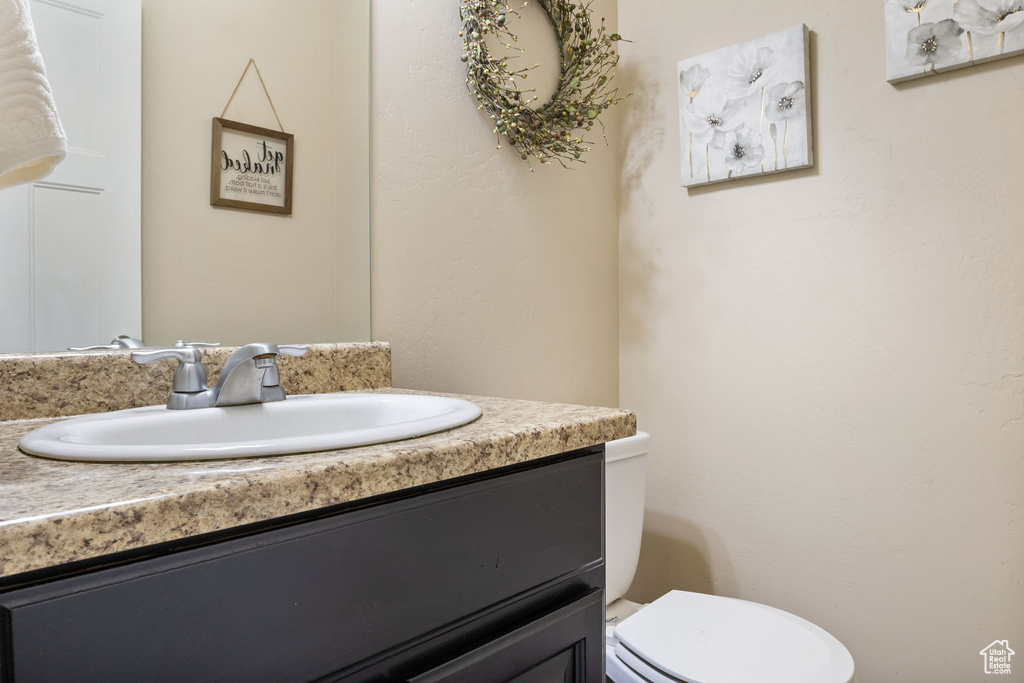 Half bathroom with vanity and toilet