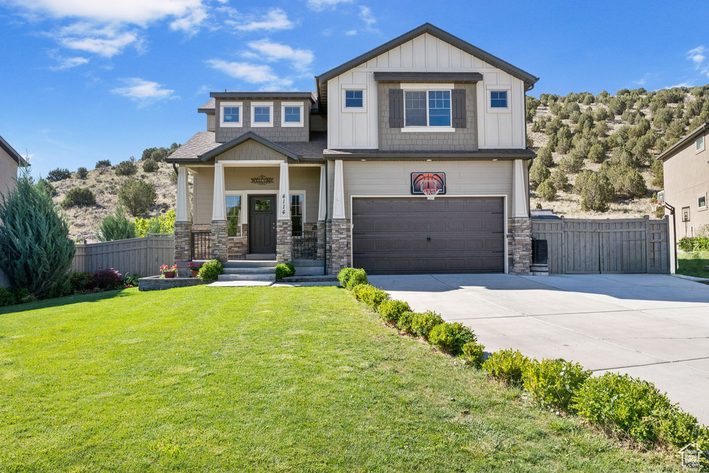 Craftsman inspired home featuring driveway, an attached garage, stone siding, and board and batten siding