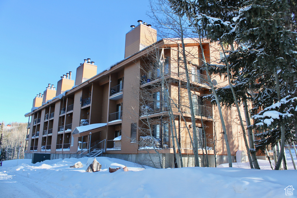 Snow covered building featuring a view of apartment building / complex