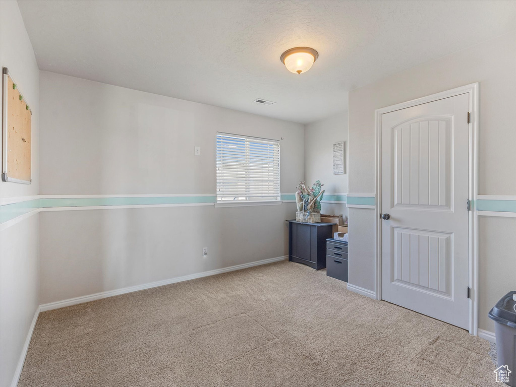 Carpeted spare room with baseboards