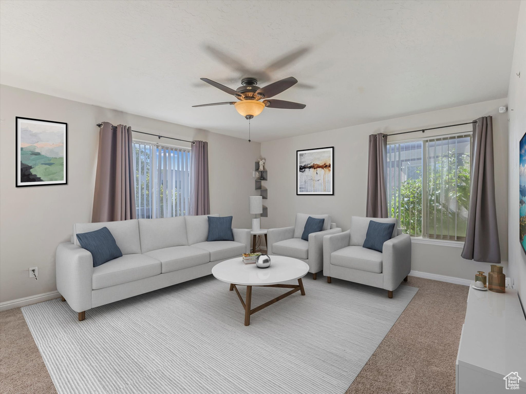 Living room featuring light carpet, baseboards, and a ceiling fan